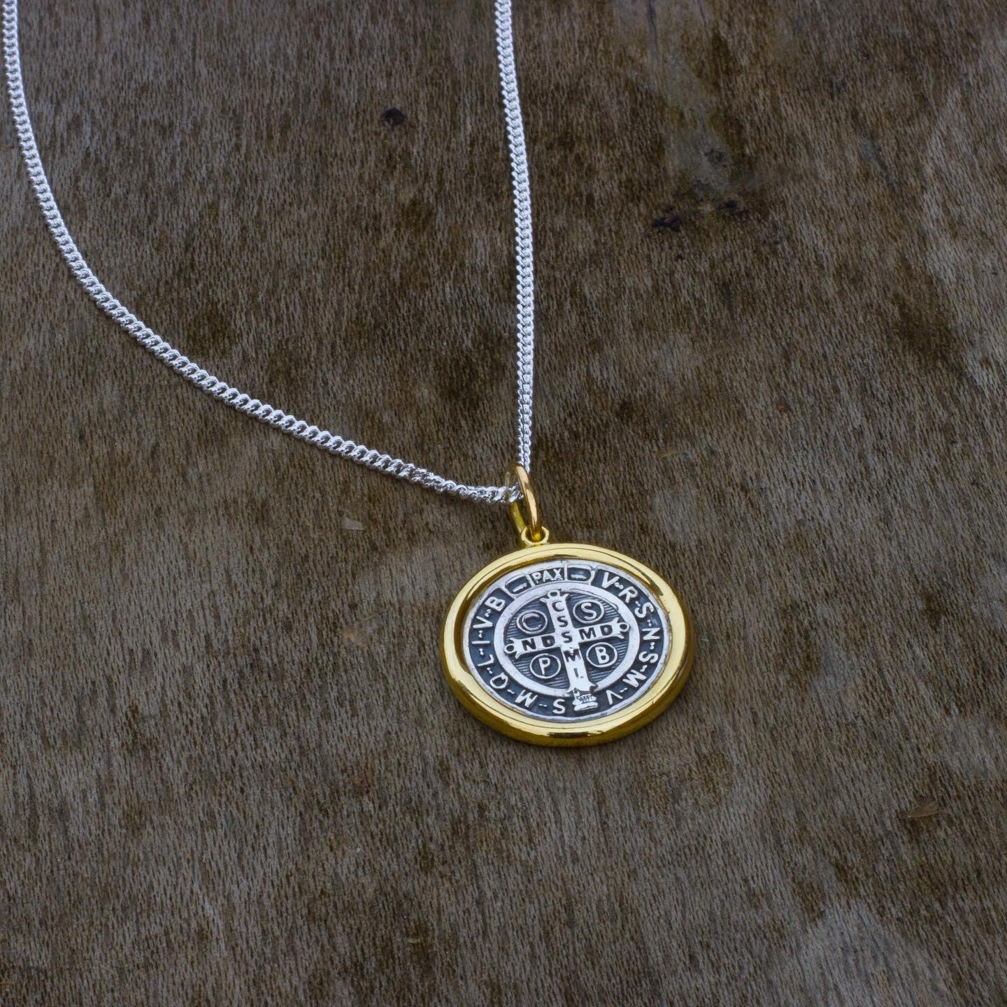 Collar San Benito en oro y plata, símbolo de protección y elegancia.