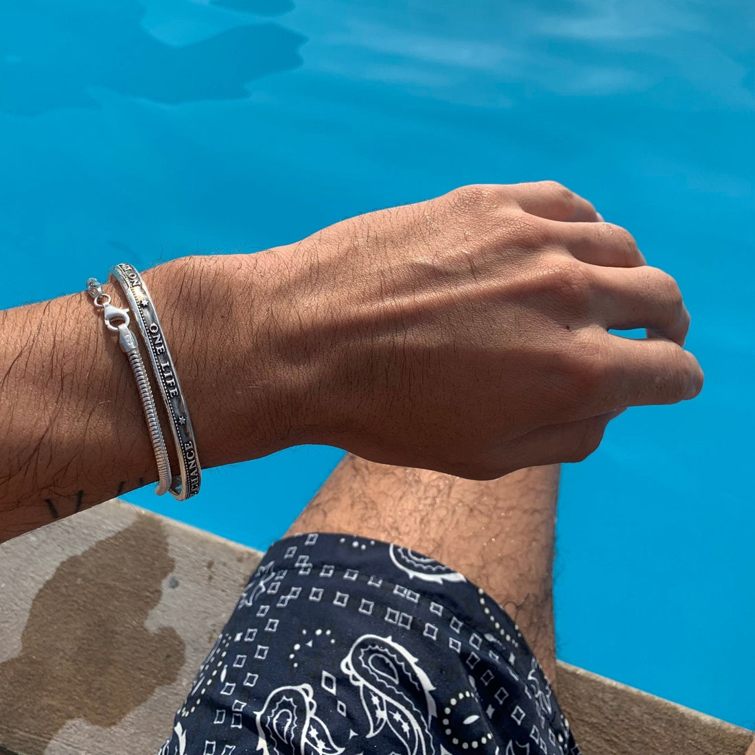 Brazalete One Life y pulsera de plata sobre la muñeca para elegir la talla correcta